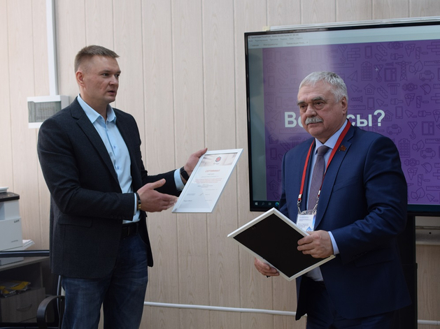 Сергей Карташов вручает Игорю Туберу сертификаты, подтверждающие статус авторизованного учебного центра